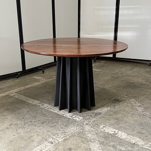 Round American oak table with black metal base, 48" wide and 29.5" tall, ideal for modern dining or.