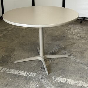 Pewter round table with sleek silver base, ideal for modern dining or office spaces.