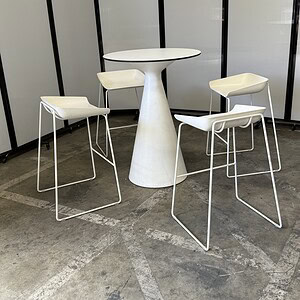 White Coalesse scoop bar height stools with no cushions for contemporary seating.