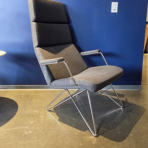 Modern high-back grey lounge chair with sleek metal armrests and frame.