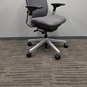 Ergonomic Steelcase Amia office chair with silver frame and grey upholstery for comfort and support.