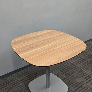 Walnut top round table with silver base, ideal for office or conference rooms.
