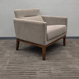 Armchair with neutral grey upholstery and espresso wood legs, perfect for contemporary office or lou.
