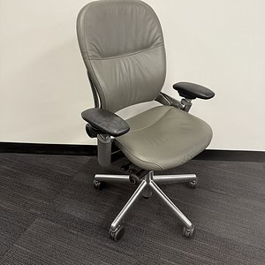 Office chair with grey leather upholstery, ergonomic design, and adjustable features. Perfect for pr.