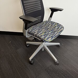 Ergonomic office chair with black mesh back and designer fabric seat for comfort.
