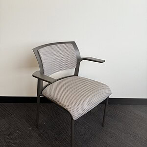 Modern Steelcase Cobi stacking chair in white and neutral tones.