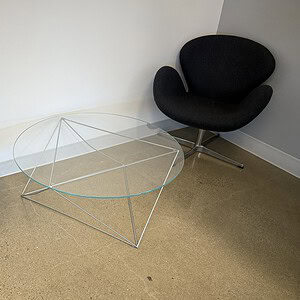 Grey lounge chair and glass coffee table for modern outdoor or indoor relaxation spaces. Stylish, co.