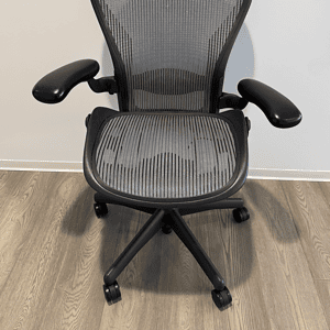 Herman Miller Aeron ergonomic office chair with mesh back and adjustable arms.
