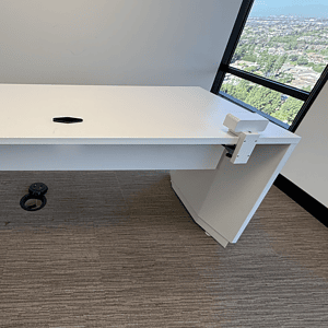 Height adjustable white office desk with electric lift system for ergonomic workspace.