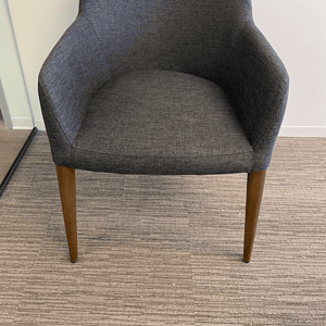 Grey fabric guest chair with wooden legs, ideal for office or reception areas.