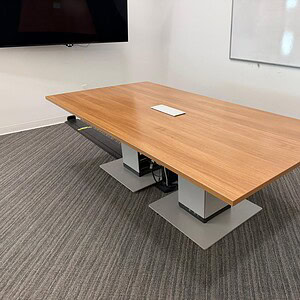 Steelcase 9x4 powered wooden conference table with silver base for modern office meetings.