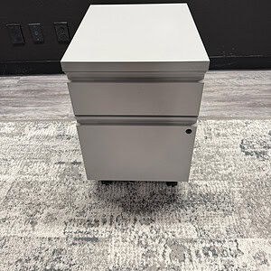 Mobile silver pedestal with lockable drawers for workspace convenience.
