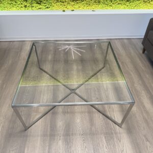 Modern glass and steel coffee table with geometric design, 3x3x16 inches.