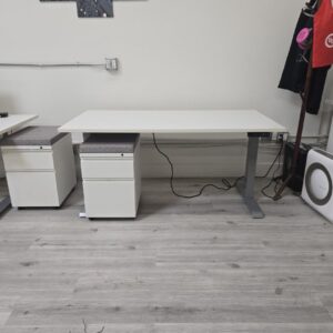 Adjustable height desk with mobile pedestal, perfect for ergonomic workspace setups. Modern white fi.
