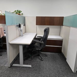 Autostrada office desk with overhead and lateral file cabinets, glass partitions, and ergonomic chai.