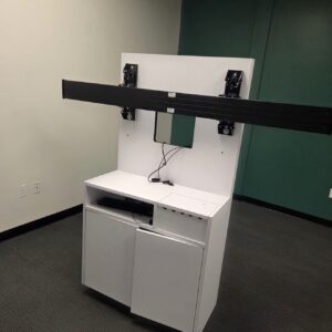 TV wall mount with white storage cabinet for electronics.
