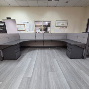 Modern gray office cubicles with workstations and storage in a professional workspace.
