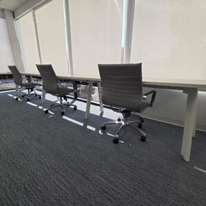 Ergonomic office chairs and spacious workstations in a bright, modern office environment.
