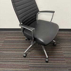 Modern black executive office chair with adjustable height and swivel base.