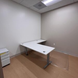 Office workspace with a white desk in a modern, minimalistic room.