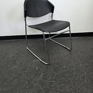 Modern black and chrome breakroom stack chair for office or breakroom use.