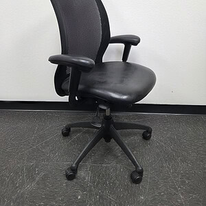 Black ergonomic task chair with mesh back and adjustable armrests.