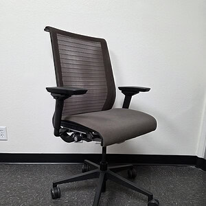 Black mesh back office chair with adjustable arms and tilt lock.