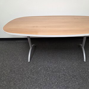 Haworth 60x36 walnut and white oval top table with steel legs.
