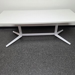 White rectangular table with steel legs for office or conference room.