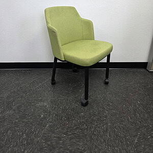 Green office accent chair with casters and armrests for workspace.