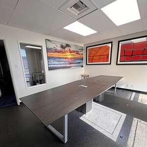 Spacious office conference room with artwork and large table.