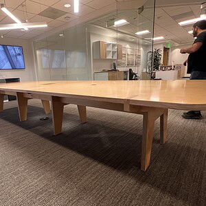 Large maple veneer conference table in modern office setting.