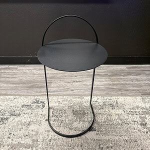 Contemporary black metal end table with handle and round top.