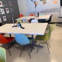 Modern conference room with colorful chairs and white tables at Cube World USA.