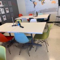 Modern conference room with colorful chairs and white tables at Cube World USA.