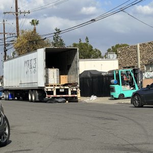Large delivery truck unloading goods in an urban area for shipping services.