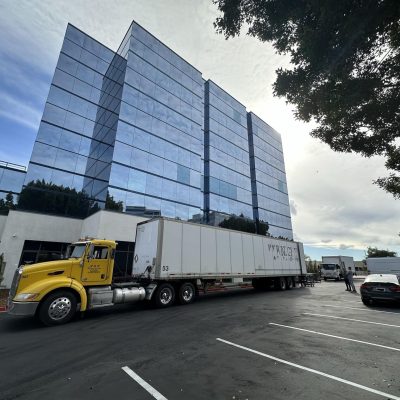 Modern office building with Cube World USA delivery truck in front.