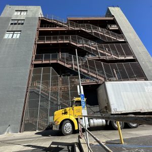 Modern industrial building with external staircase and shipping dock.