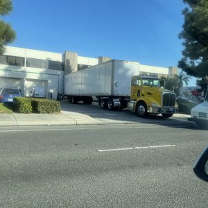 Large yellow truck delivering goods at Cube World USA facility.