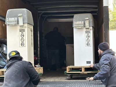 Office furniture being unloaded from a moving truck for liquidation sale.