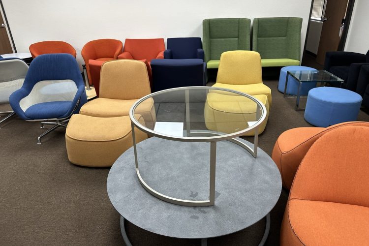 Colorful modern lounge chairs and tables in a professional office setting.
