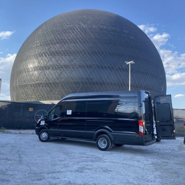 Black delivery van parked near a large spherical building during relocation.