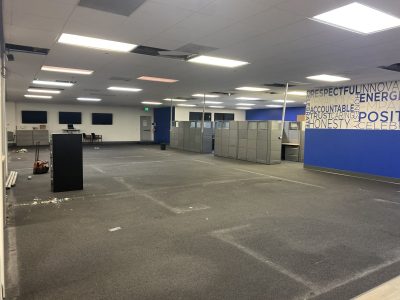 Empty office space with furniture liquidation setup, cubicles, and open area.