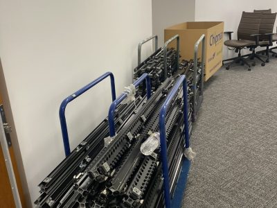 Stacked metal and plastic office furniture parts in a liquidation space.