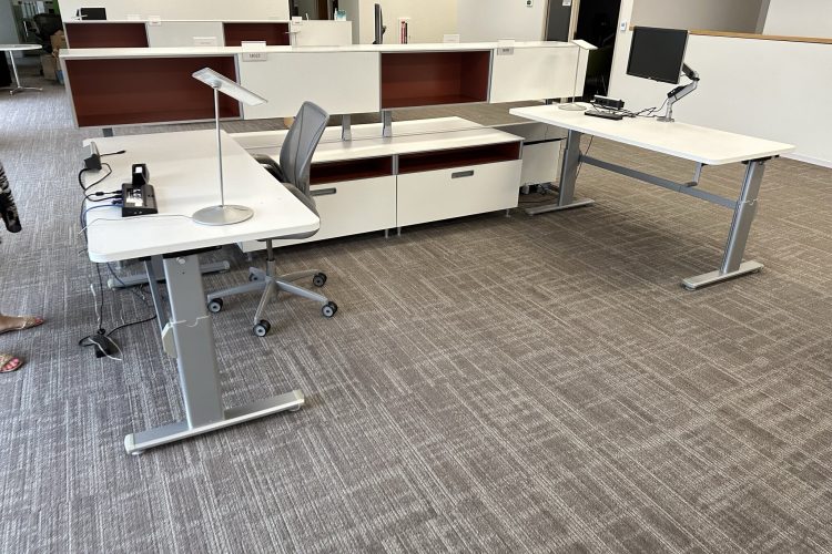 Modern office workspace with desks, chairs, and computers.