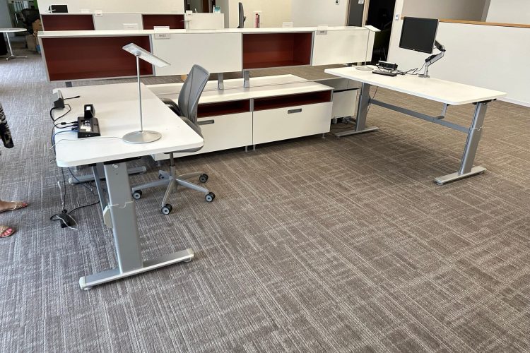 Modern office workspace with desks, chairs, and computers.