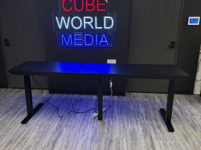 Modern neon sign for Cube World USA in office setting.