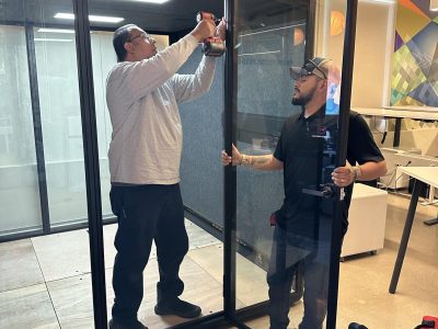 Office glass partition being installed during facility relocation.