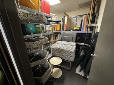 Office storage closet with shelves, chairs, and supplies for workspace organization.