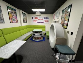 Modern office lounge with green seating and creative decor.